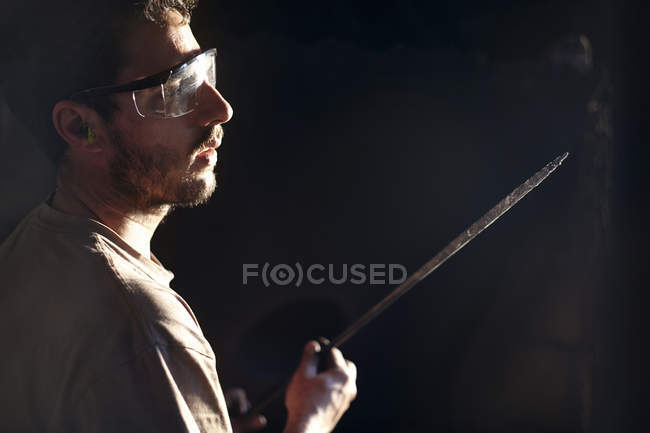 Ferreiro examinando lâmina de ferro — Fotografia de Stock