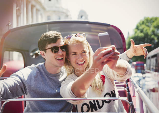 Casal tomando selfie em ônibus de dois andares em Londres — Fotografia de Stock