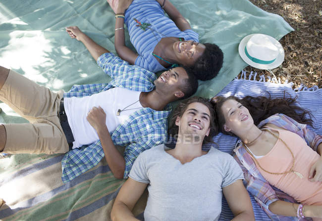 Amigos acostados en mantas al aire libre - foto de stock