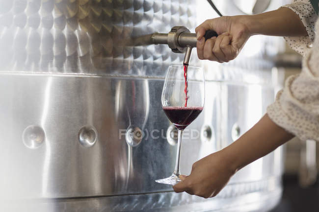 Vintner barrel tasting red wine from stainless steel vat — Stock Photo