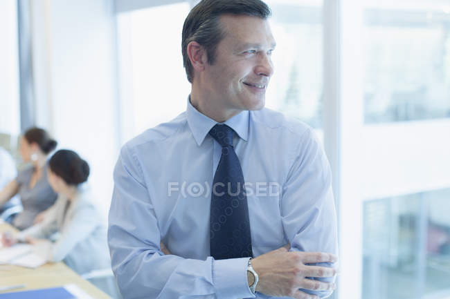 Бізнесмен посміхається в офісі в приміщенні — стокове фото