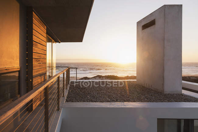Modern house overlooking ocean at sunset — Stock Photo