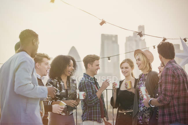 Giovani amici adulti che bevono e si godono la festa sul tetto — Foto stock