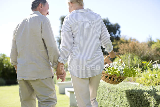 Casal sênior de mãos dadas no jardim — Fotografia de Stock