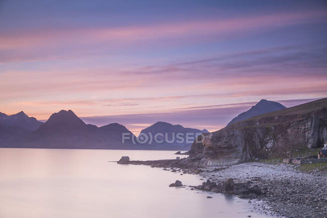 Cielo rosado del atardecer sobre montañas y lago tranquilo, Elgol, Skye, Escocia - foto de stock
