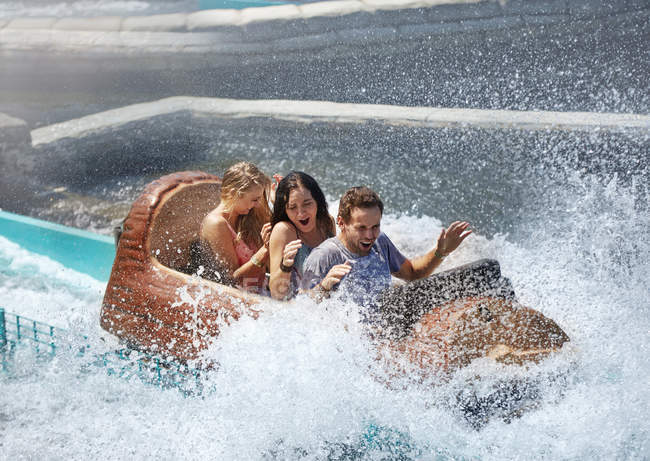 Amigos ficando salpicado em passeio de parque de diversões de log de água — Fotografia de Stock