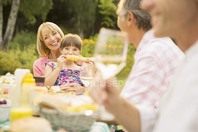Família feliz comer à mesa no quintal — Fotografia de Stock