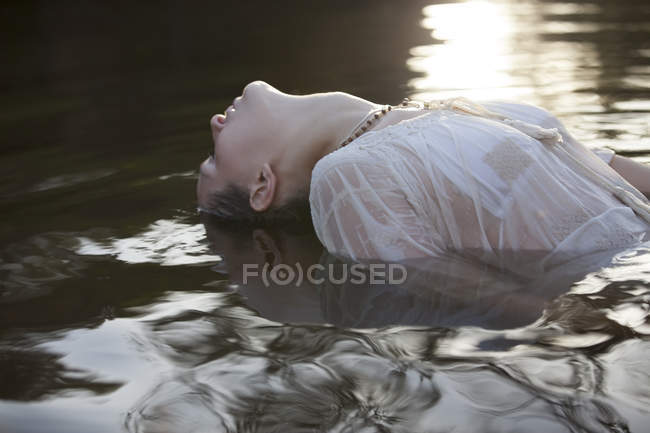 Frau lehnt sich kopfüber in Fluss zurück — Stockfoto