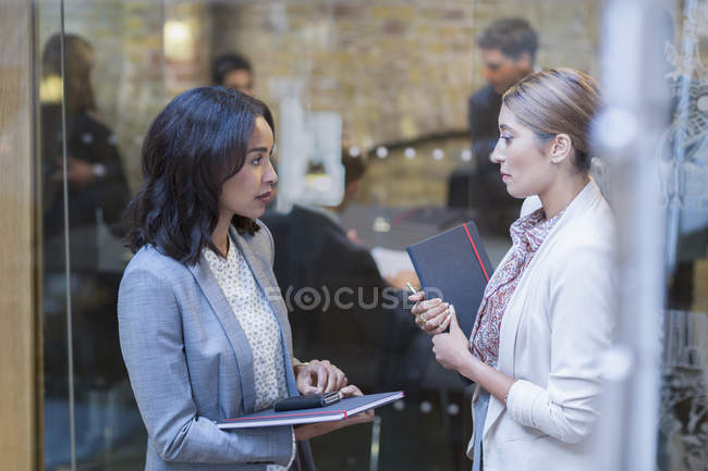 Businesswomen talking outside conference room meeting — Stock Photo
