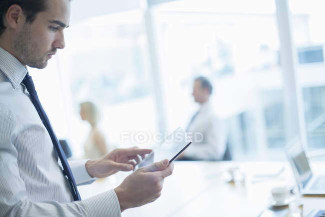 Uomo d'affari che utilizza tablet digitale in sala conferenze — Foto stock
