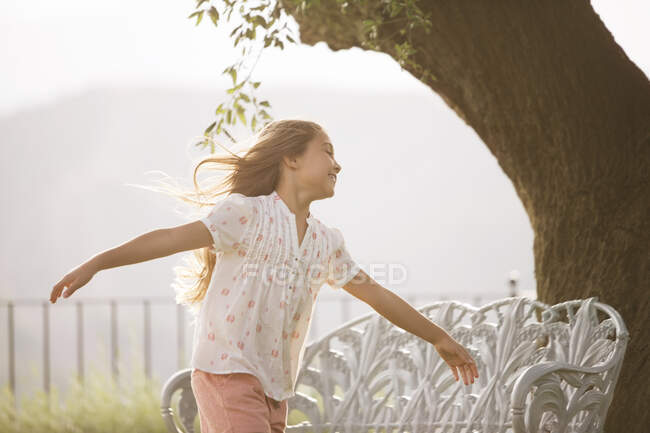 Chica corriendo con los brazos extendidos - foto de stock