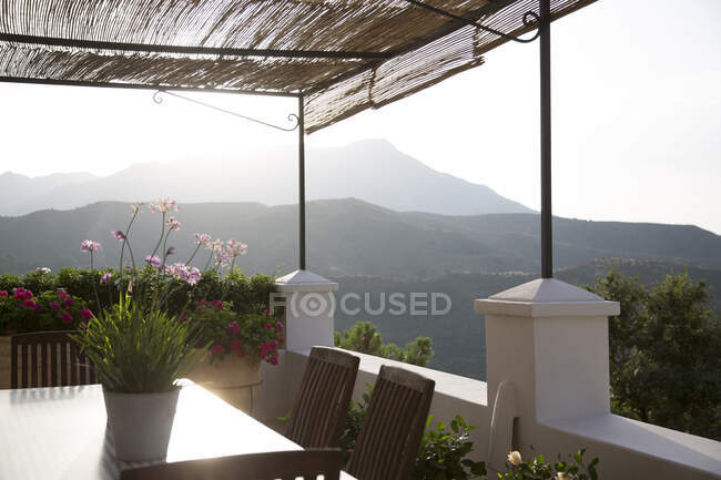 Tavolo e sedie sul balcone con vista sulle montagne — Foto stock