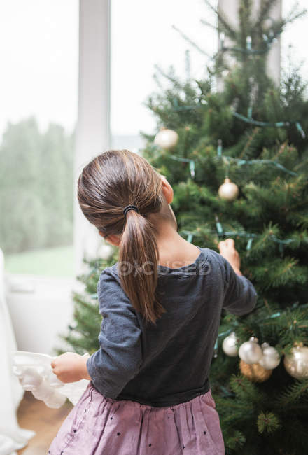 Toddler girl decorating Christmas tree — Stock Photo