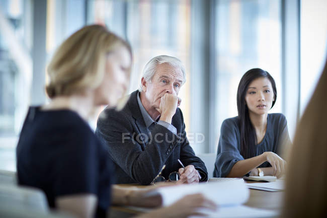 Aufmerksame Seniorin hört bei Besprechung zu — Stockfoto