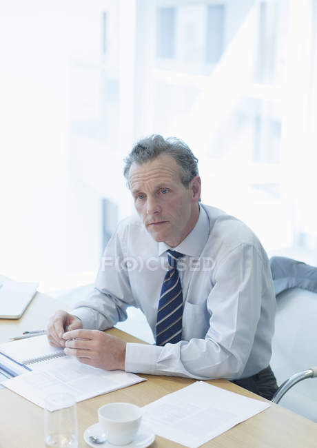 Бізнесмен сидить на робочому столі в офісі — стокове фото