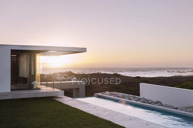 Сучасний будинок з видом на океан на заході сонця — стокове фото