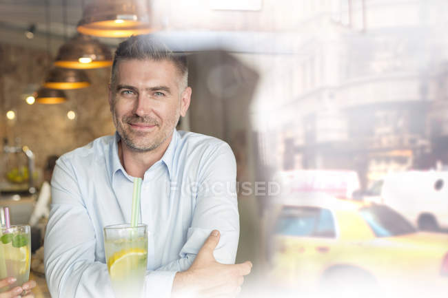 Portrait confident man at urban cafe window — Stock Photo