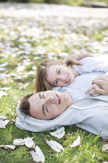 Пара, що лежить у траві на відкритому повітрі — стокове фото