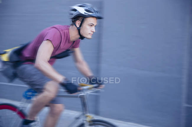 Mensageiro de bicicleta focado com capacete em movimento — Fotografia de Stock