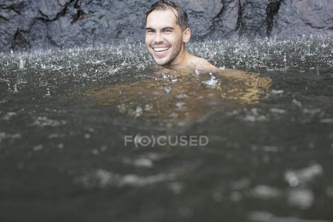 Дождь, падающий на человека в озере — стоковое фото