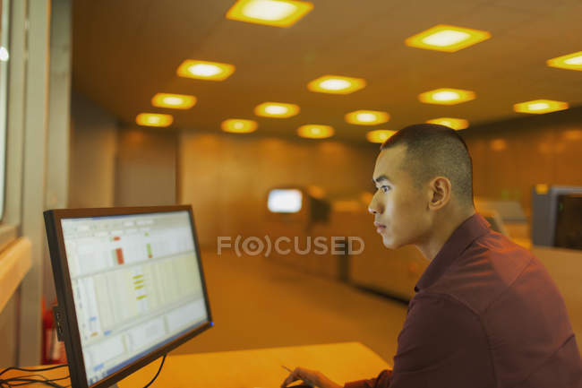 Ingeniero que trabaja en la computadora en la sala de control de fábrica - foto de stock