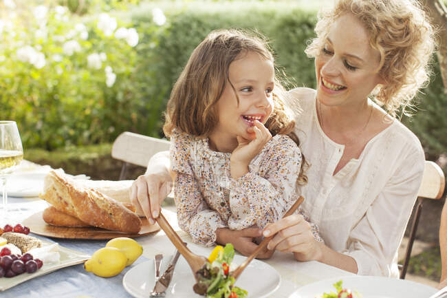 Mother and daughter eating in garden — Stock Photo