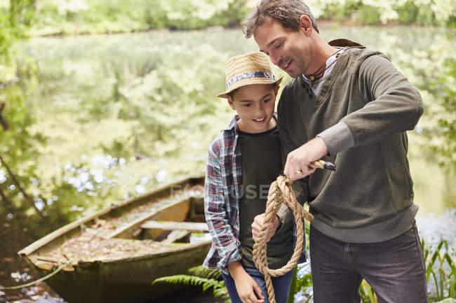 Father teaching son how to tie a rope knot — Stock Photo