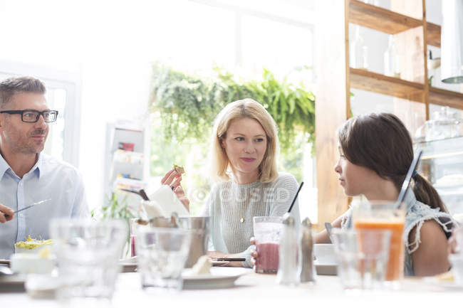 Family eating lunch at cafe table — Stock Photo