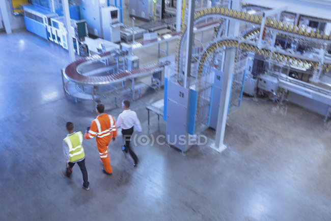 Workers and supervisor walking in factory — Stock Photo