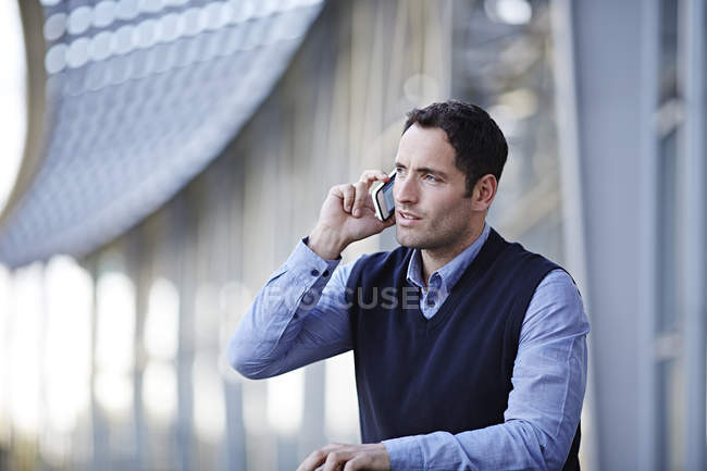 Успішний дорослий бізнесмен говорить на мобільному телефоні на відкритому повітрі — стокове фото