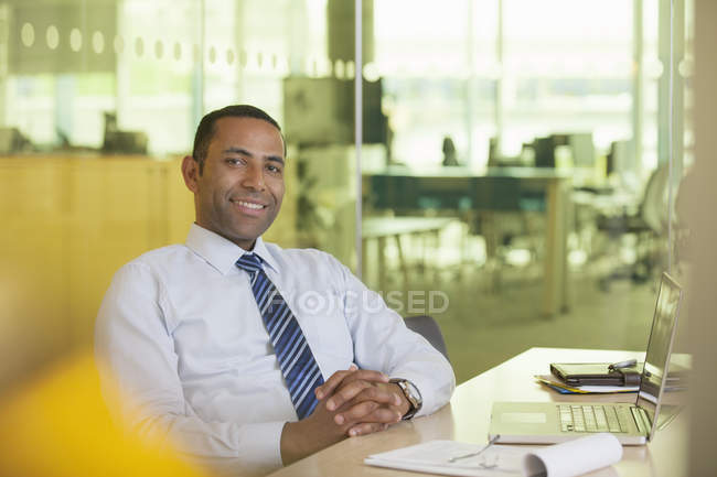 Empresário sorrindo para a mesa — Fotografia de Stock