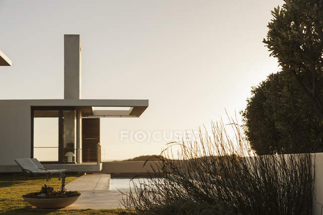 Lap piscina lungo casa moderna al tramonto — Foto stock