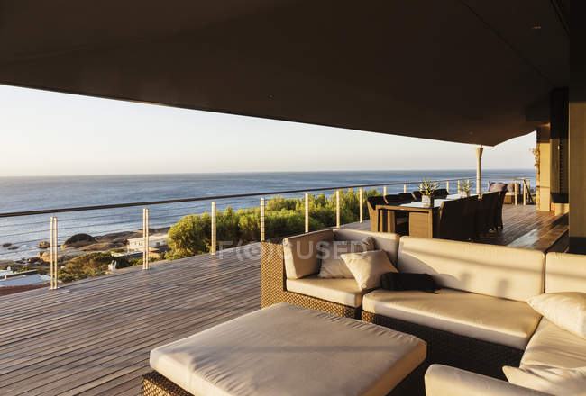 Canapé et table sur patio de luxe surplombant l'océan — Photo de stock