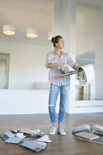 Woman looking at fabric swatches in new house — Stock Photo