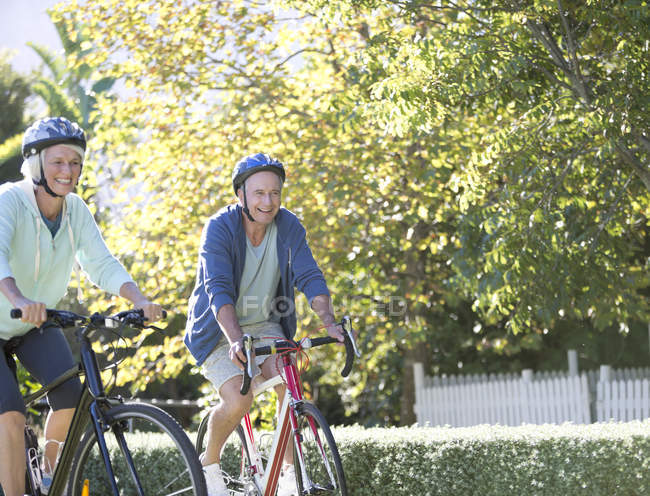 Senior couple riding bicycles in park — Stock Photo