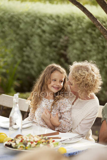 Mère et fille assises à la table à l'extérieur — Photo de stock