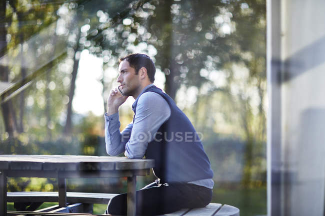 Успешный взрослый бизнесмен разговаривает по мобильному телефону снаружи — стоковое фото