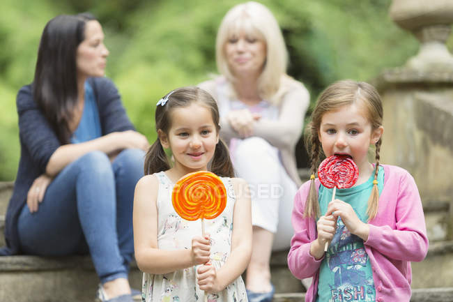 Girls with lollipops in park — Stock Photo