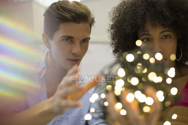 Les gens d'affaires examinant boule de lumières à cordes — Photo de stock