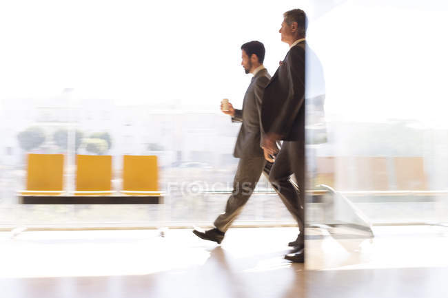 Businessmen walking in airport corridor — Stock Photo