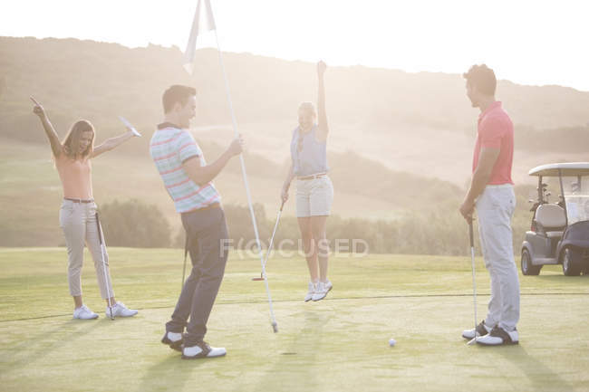 Begeisterte junge Freunde auf dem Golfplatz — Stockfoto