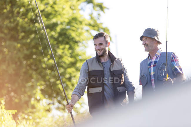Padre e hijo adulto con cañas de pescar - foto de stock