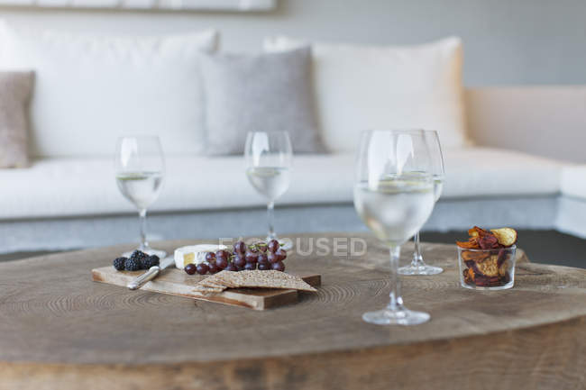 Wine and cheese on wooden coffee table — Stock Photo