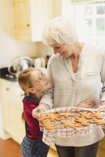Enkelin umarmt Großmutter beim Lebkuchenbacken — Stockfoto