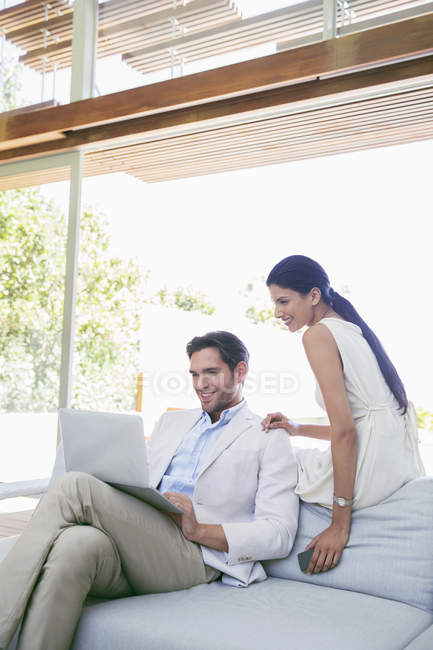 Молода приваблива пара використовує ноутбук на дивані — стокове фото