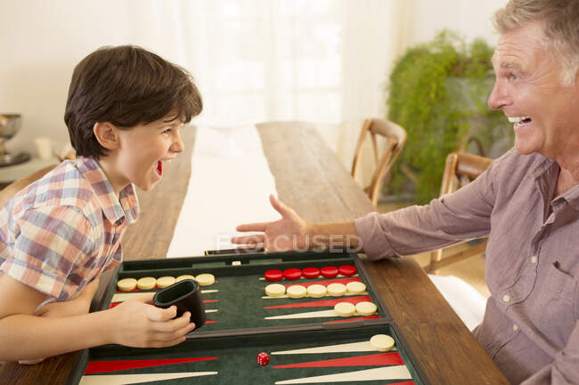 Abuelo y nieto jugando backgammon - foto de stock