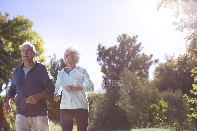 Senior couple running in park — Stock Photo