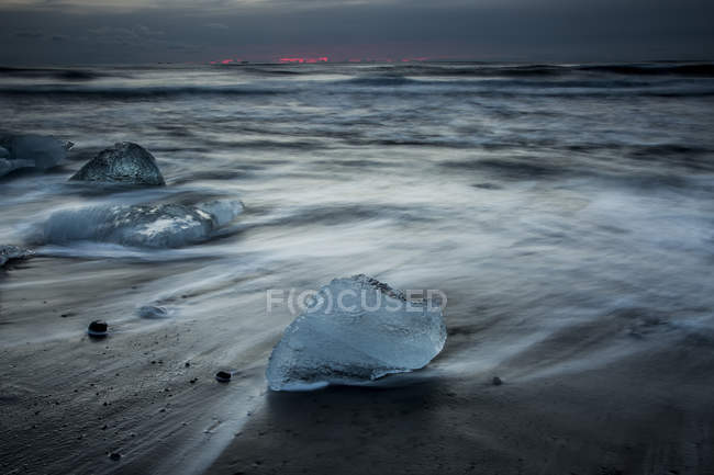 Glace sur la plage tempétueuse de l'océan froid, Islande — Photo de stock