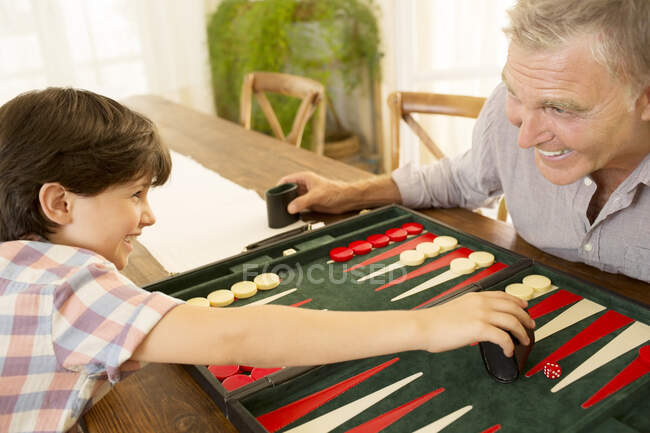 Grandfather and grandson playing backgammon — Stock Photo