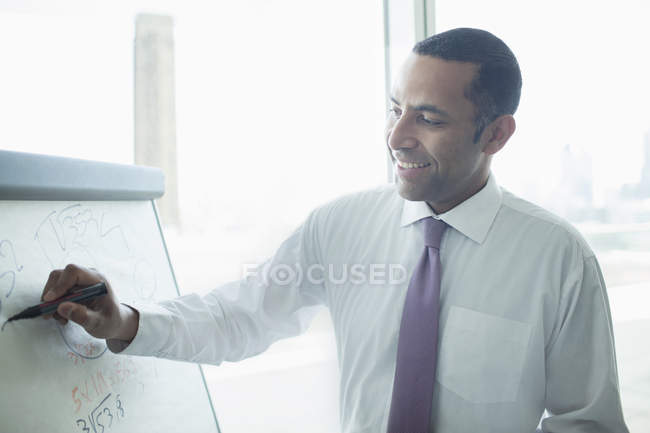 Uomo d'affari che scrive sulla lavagna bianca in ufficio — Foto stock